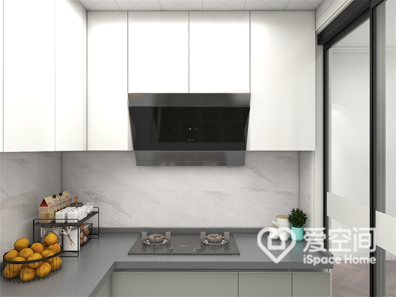 厨房空间温馨又通透，白色橱柜优雅整洁，中部搭配灰色操作台，塑造出静谧柔和的烹饪氛围。