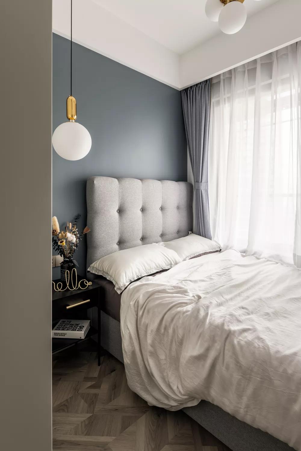 次卧是男孩房，雾霾蓝的墙漆显得宁静优雅，再加上浅灰色的床和窗帘，白色的床品、纱帘，营造出一种简约、轻松的感觉。