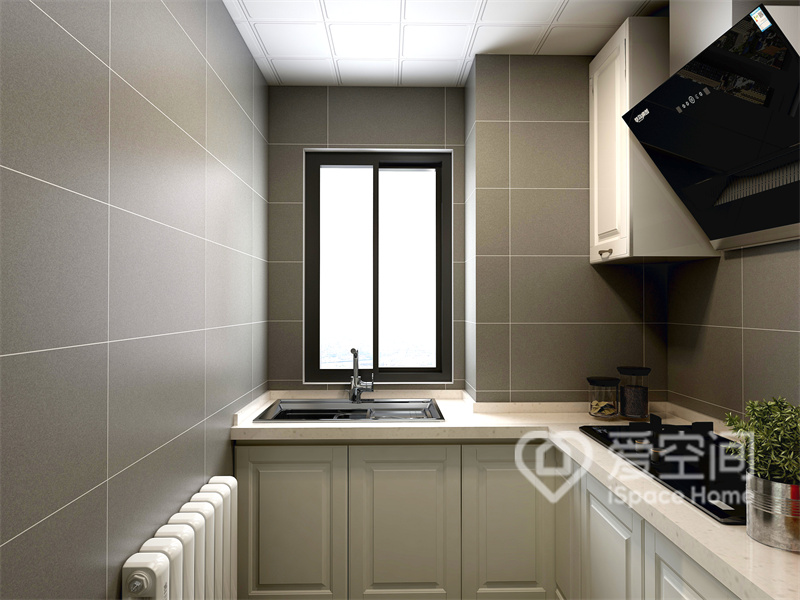 厨房空间十分有设计感，米白色橱柜营造出高级感，背景墙以灰色调为主，呈现出静谧高级的氛围。