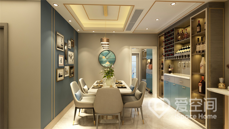 素雅的餐桌椅有种扑面而来的质朴气息，蓝色背景、装饰画和柜面共同呈现出一个时尚感较强的用餐空间。