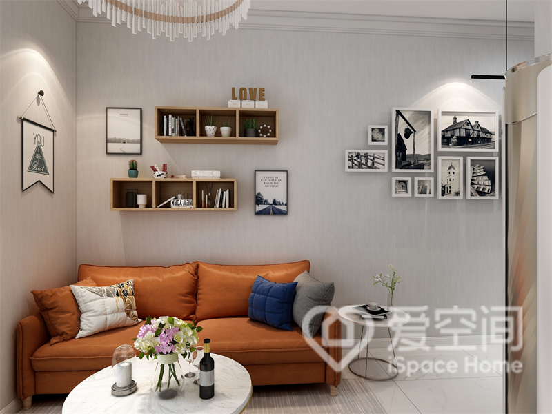 客厅空间以灰白色为背景，焦糖色沙发简洁明亮，色调轻盈，在收纳柜和装饰画的点缀下，平呈现出文艺气息。