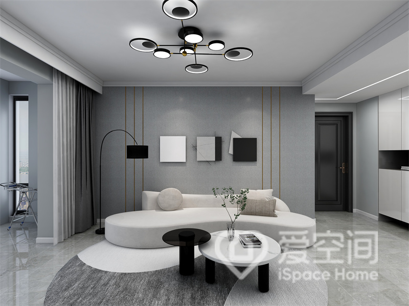 客廳利用灰色系打造背景，白色曲線沙發賦予了空間簡約與雅謐，黑白茶幾帶來精致的空間氛圍。