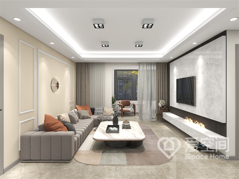客厅的设计相对较简单，沙发墙采用白色石膏线勾勒，搭配灰色沙发，简约高级，时尚耐看。