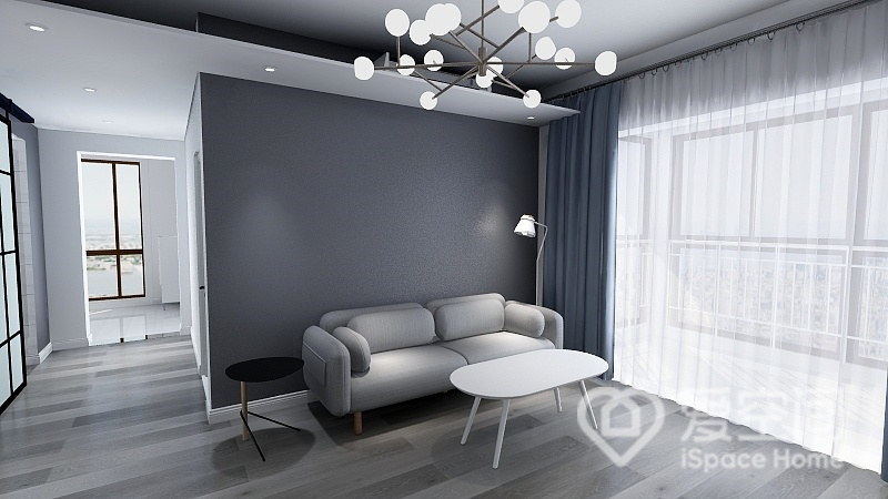 客厅空间以灰色和白色来塑造，家具恰到好处的点缀让空间显得很温润，呈现出轻松怡人的氛围。
