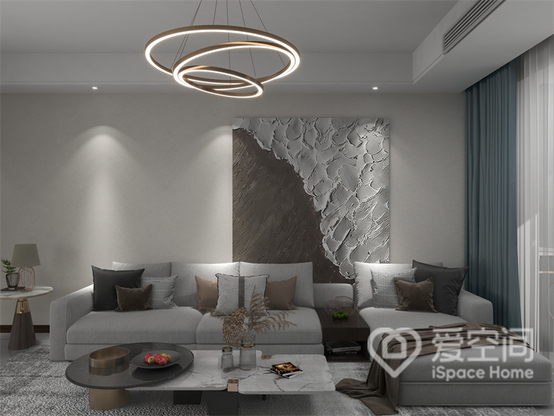 客厅以米灰色为主色调，沙发墙采用留白手法处理，筒灯+装饰画的组合带来舒适温馨的视觉感受。