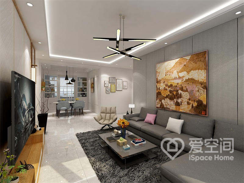 客厅空间背景选用了白色和灰色来搭配，深灰色布艺沙发搭配灰褐色茶几、地毯，令空间散发出都市的气息。