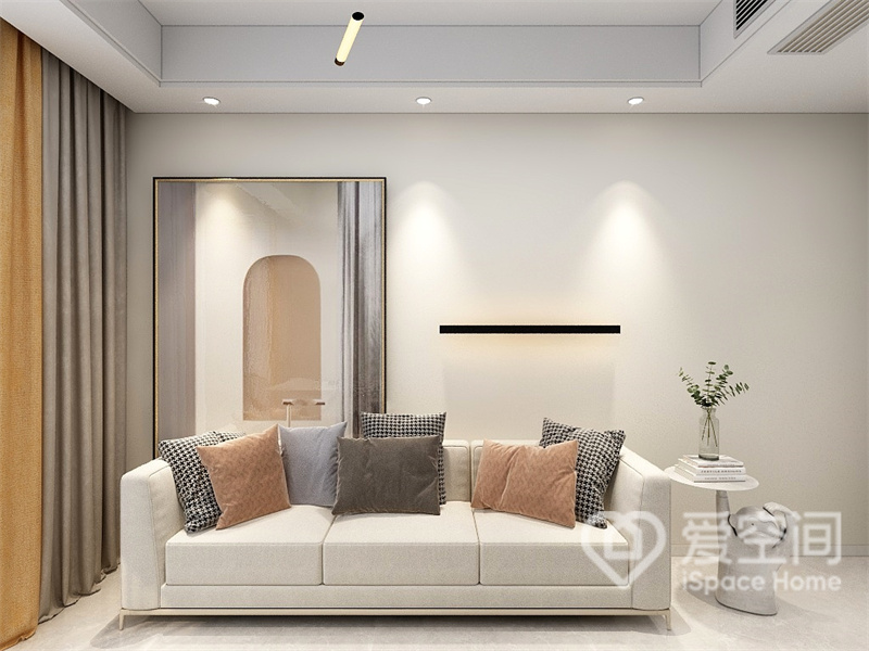 客厅的设计十分节制，让人很容易捕捉到沙发上的抱枕纹样，艺术画令视觉焦点更为明确。