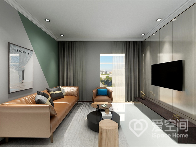 沙发墙采用灰色与绿色两种色系拼接，简约高级，焦糖色皮质沙发优雅有格调，黑色地柜与茶几搭配其中，展现出现代风格中的艺术美感。