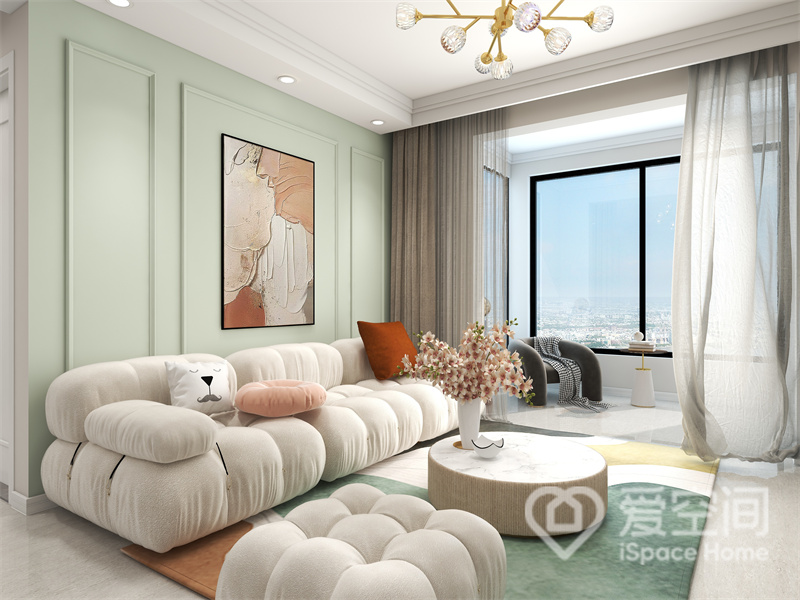 客厅使用柔和的薄荷绿为背景，搭配暖白色法式沙发，尽显高级温婉气质，临窗位置增设了休闲桌椅，客厅生活更加多元化。