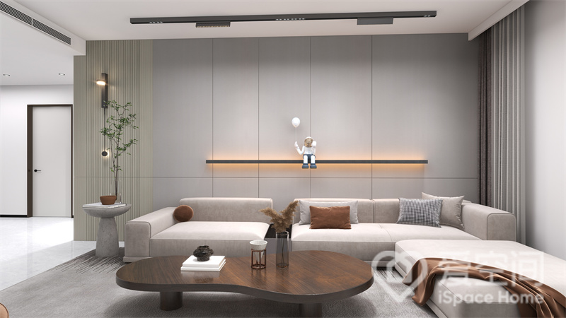 客厅采用米灰色为主色调，家具突出简洁大气，沙发造型简约低矮，令客厅看上去更加开阔。