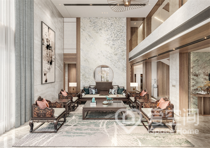 客厅挑高设计，石材与原木碰撞设计提升了整体格调，新中式简雅家具陈设其中，淡雅含蓄。