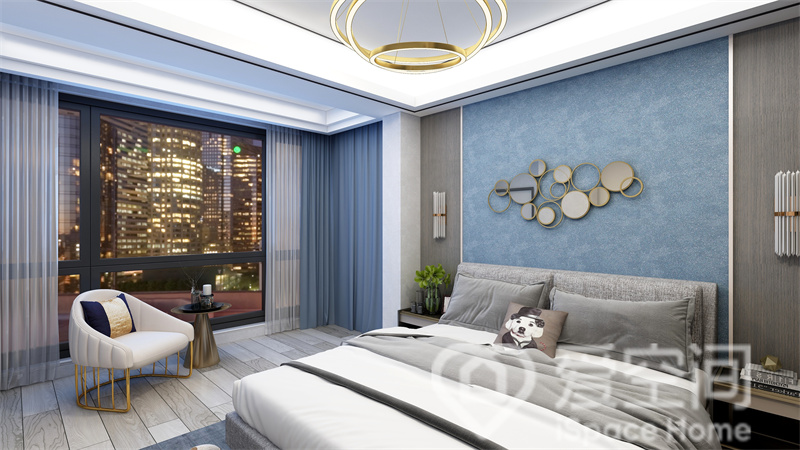 主卧与阳台空间合并，呈现出开放格局，蓝色色块填充背景，设计感十足，咖白色床品舒适而温馨。