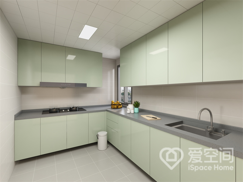 厨房面积宽敞，动线布置为L型，薄荷绿橱柜与浅灰色操作台的搭配，令空间充满简约舒适的视觉氛围。