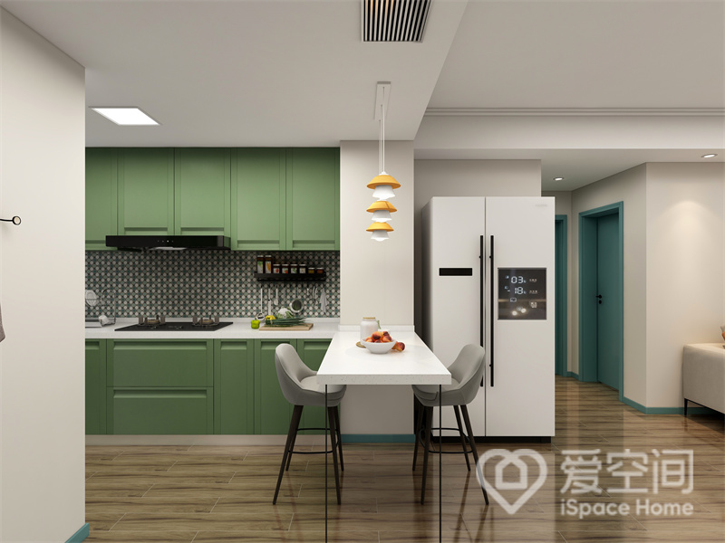 餐厨一体设计，地面通铺原木地板，吧台的点缀突出高级感，绿色橱柜营造出简约、文艺的视觉效果。