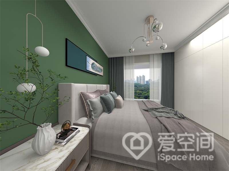 主卧选用绿色作为背景墙，灰白色家具放置其中整个空间显得十分干净，隐形衣柜保持了空间的整洁感。