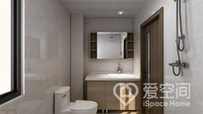 卫浴空间格局紧凑，米灰色背景营造出温馨氛围，洗手柜和镜柜自带收纳系统，展现出简约美感。