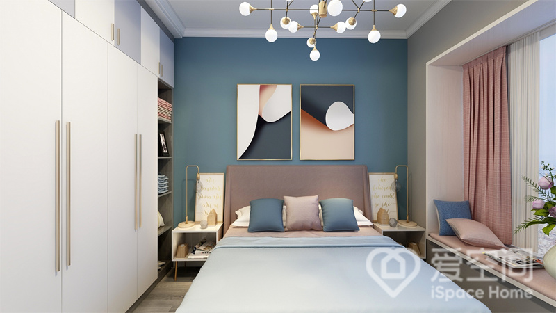 次卧空间中，蓝色的克制与冷静与豆沙粉的柔情相碰撞，装饰画及灯具装饰令卧室充满精致感。