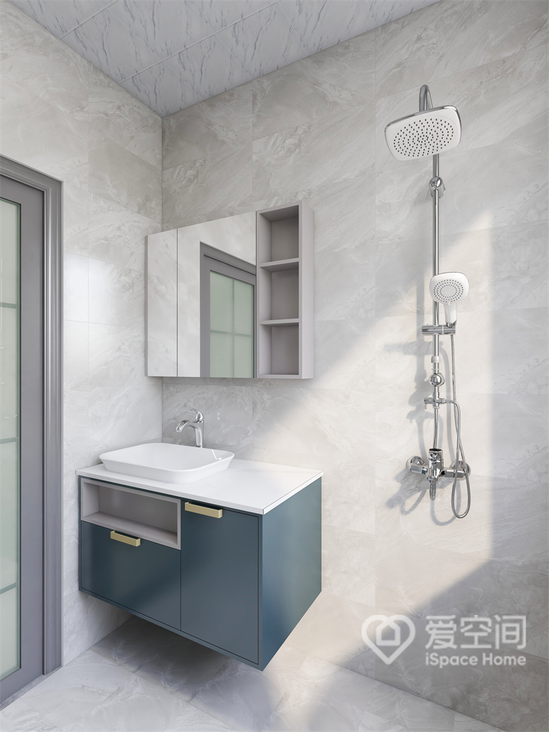 米色背景砖与白色地砖搭配，使得卫浴空间更有层次，蓝色悬浮式洗手柜令空间隐约中透露着几分暖意，别具风味。
