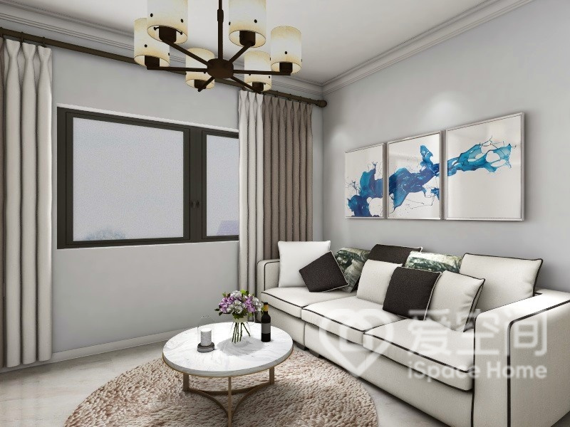 客廳空間大量運用白灰色系打造，白色沙發搭配灰色抱枕點綴，恰到好處的精致。