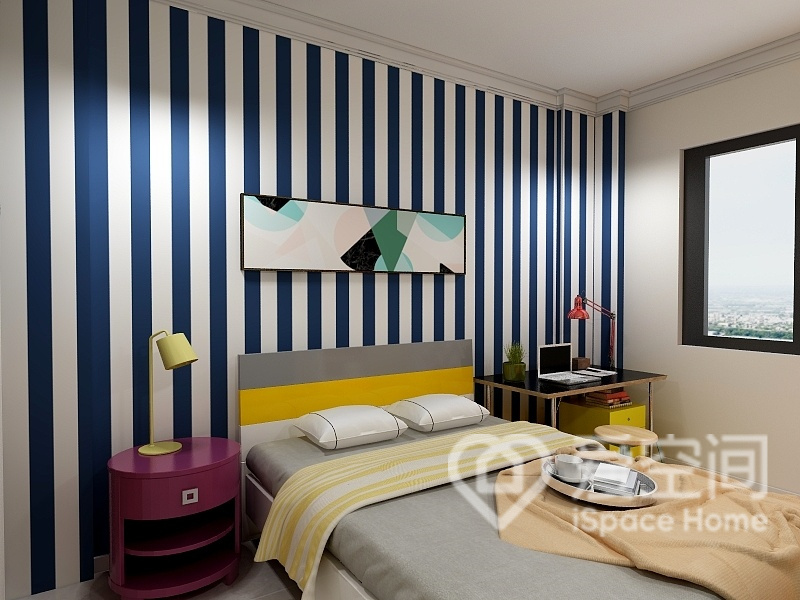 次卧背景墙铺贴蓝白条纹壁纸，并搭配灰黄色床品，空间时尚感强。