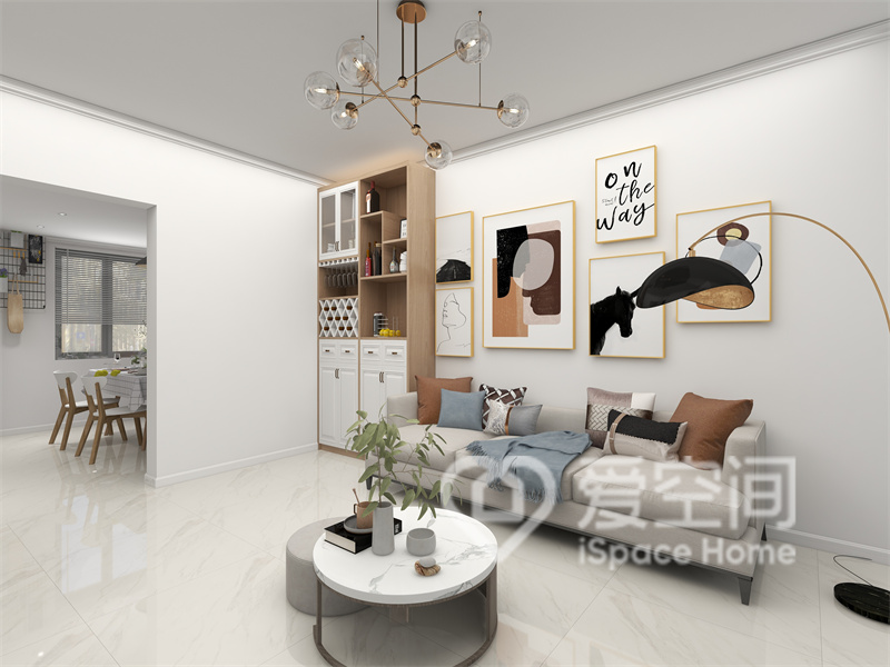 白色空间中放置了灰色沙发、低矮茶几、装饰画等元素，从视觉上增大了客厅的空间。