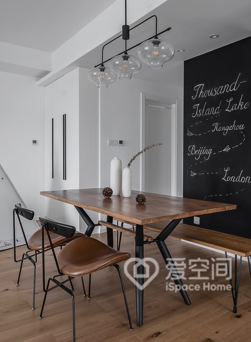 餐厅背景墙黑白搭配，温润的木质餐桌椅温馨感强烈，这里显得温暖又舒适。