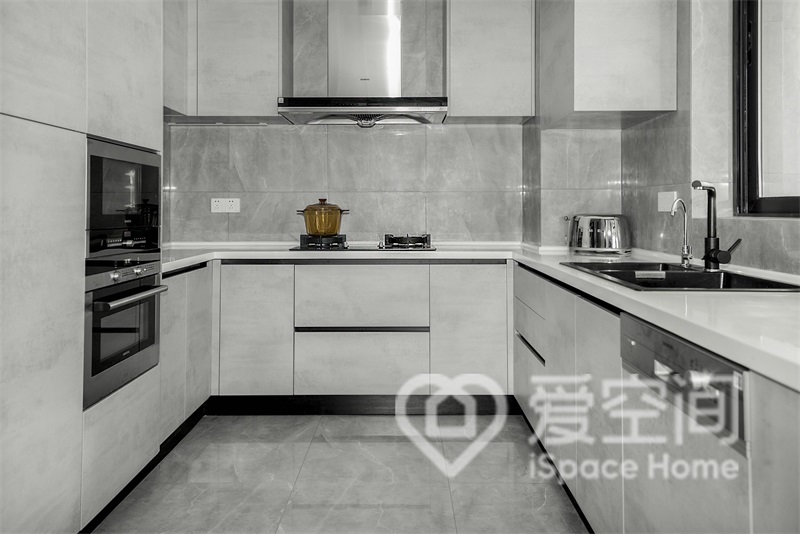 灰白色櫥柜與灰色背景巧妙的融合在一起，營造出了一個舒適的烹飪空間。