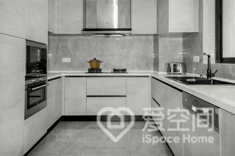 廚房空間整體配色一致，灰色櫥柜搭配白色工作臺設計，提升了空間的層次感。