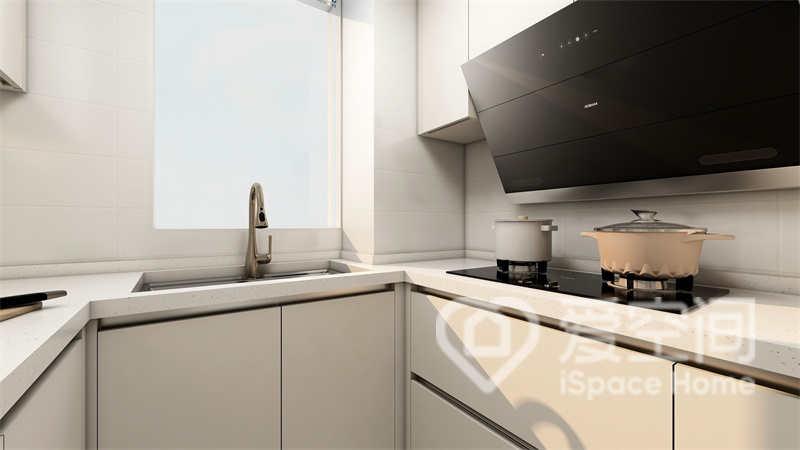 白色的U字型厨房在使用中很舒适，特别是厨房采取了倾斜吸油烟机的设计，即可以去除油烟又具有一定装饰效果