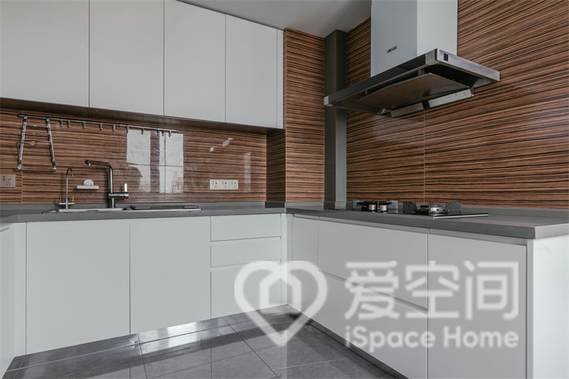 廚房的設計突出了精致感和層次感，白色櫥柜搭配咖色背景墻，構成一個和諧有序的空間。