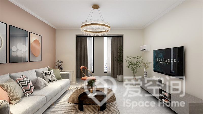 客廳采用浪漫素雅的米色和粉色墻面搭配塑造，灰色沙發與地板相輔相成，軟裝的點綴下，顯得更加的靈動。
