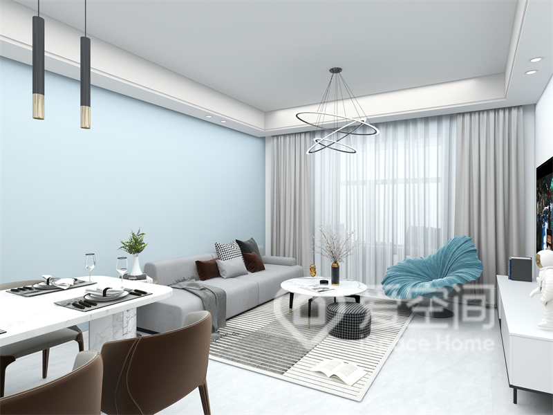 客厅的设计非常简洁，浅蓝色背景搭配灰色沙发很有现代感，给我们带来了美好的视觉享受。
