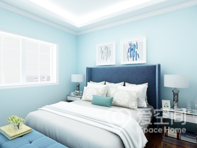 蓝色的背景塑造出温馨的主卧空间，柔软的床品让人身心舒畅，置身于此令人感到宁静和安逸。