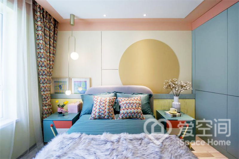 卧室选用明亮的色调，背景墙的配色也十分的丰富，搭配蓝色的床单，营造出活跃精致的休息空间。