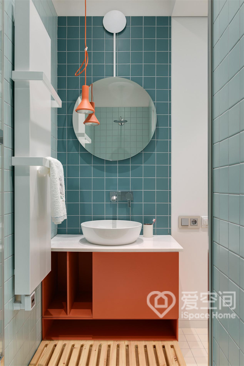 卫生间洗手池撞色设计，蓝色和橘色提升精致感，搭配垂吊灯具和明镜，空间倍感明亮。