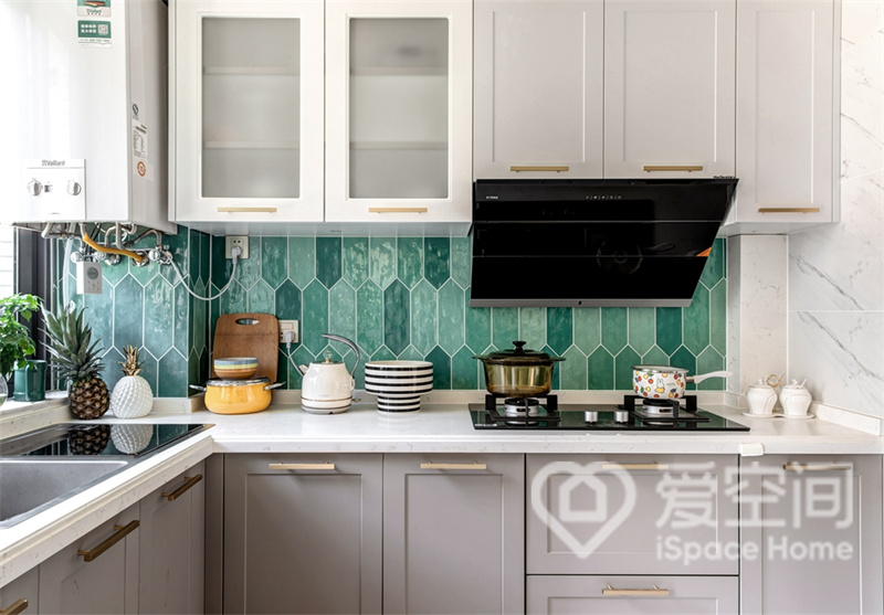 开放式的厨房，整洁卫生，橄榄绿瓷砖与白色橱柜碰撞在一起，营造出自然清新的轻奢风情。