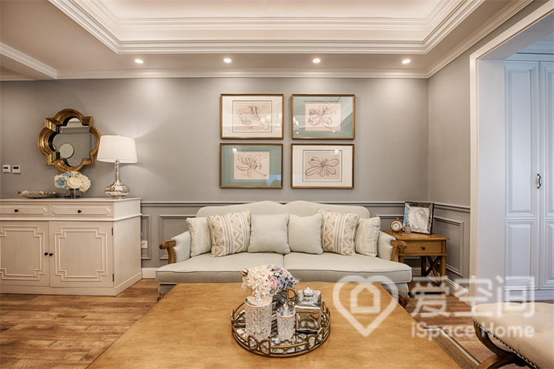 客厅原木色的地板与布艺沙发搭配地恰到好处，灰色背景墙、相框装饰画，凸显着空间的高级感。