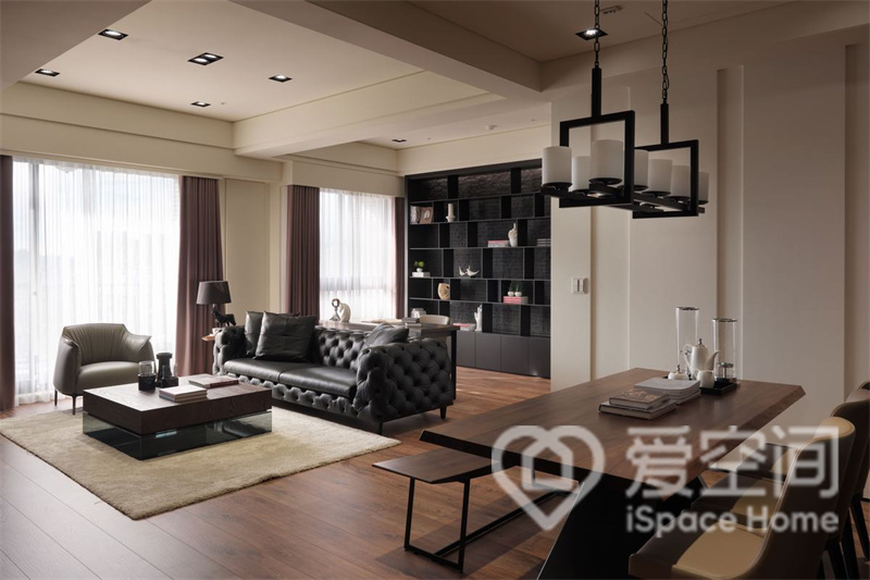 黑色皮质沙发成为客厅隔断，划分出客厅区与办公区，美观性较高。电视背景墙选用木饰面板与大理石面板做装饰，地柜与背景墙保持颜色上的统一性。
