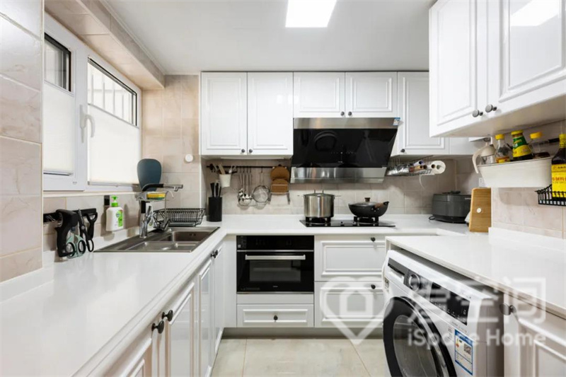 廚房呈現出一種現代質感，白色櫥柜搭配米色背景墻，溫馨又潔凈，且烘托出靜謐雅致的既視感。