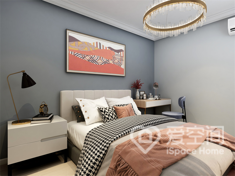 次卧背景墙以低饱和度色系为主体，搭配暖色装饰画和床品元素装饰，令纯净的空间更具有温馨的氛围。
