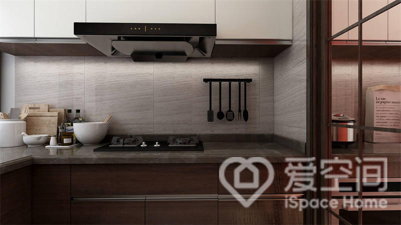 厨房大面积的灰色大理石包裹，与深浅色调的橱柜冷暖相调和，柔软的光晕令空间尽显雅致与沉稳。
