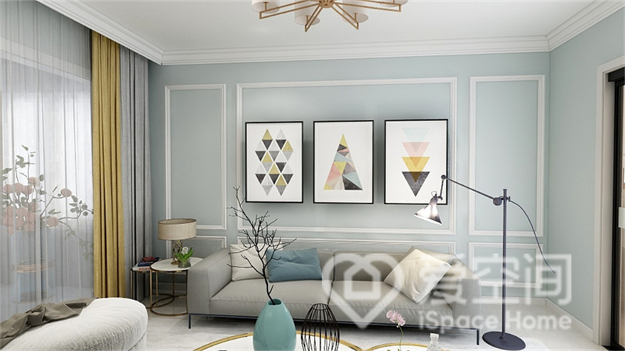 客厅的家具放置得十分灵活，蓝色背景墙浪漫而温馨，率性的装饰画提升了空间的文艺气息。