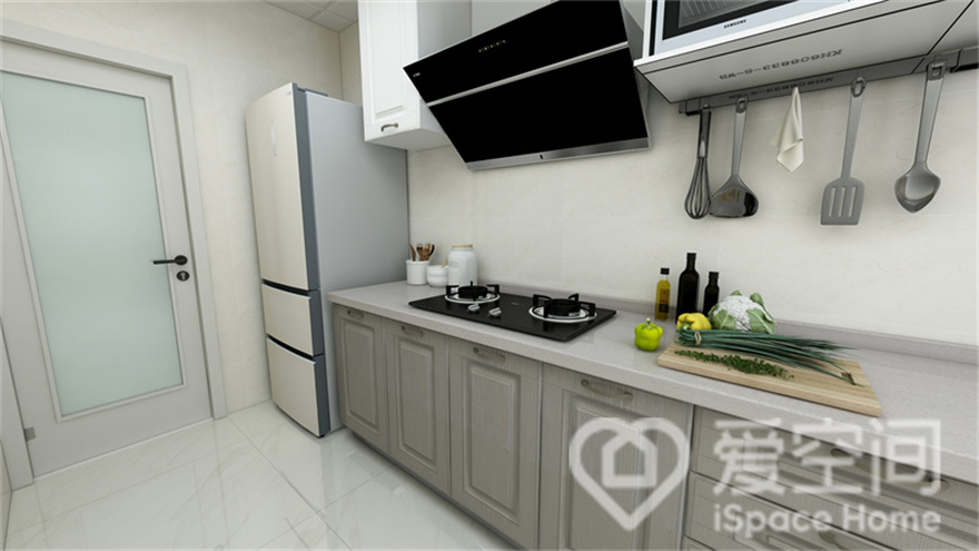 厨房定制了橱柜，一字型橱柜动线设计流畅便捷，米灰色柜面大气又美观，辉映出细腻质感。