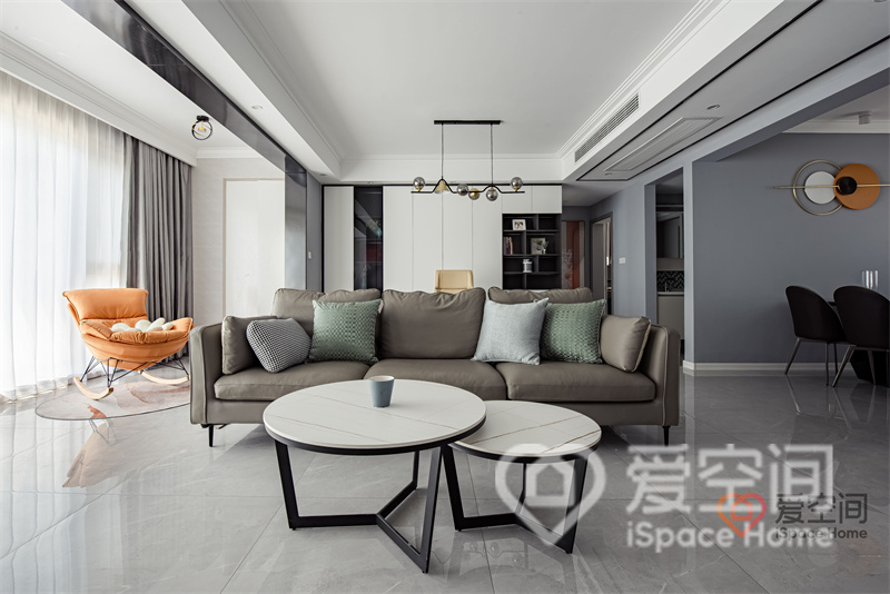 米咖色皮质沙发像浓缩的现代精华，放置在客厅中巧妙的划分出客餐空间，白色茶几集功能与美学于一体。
