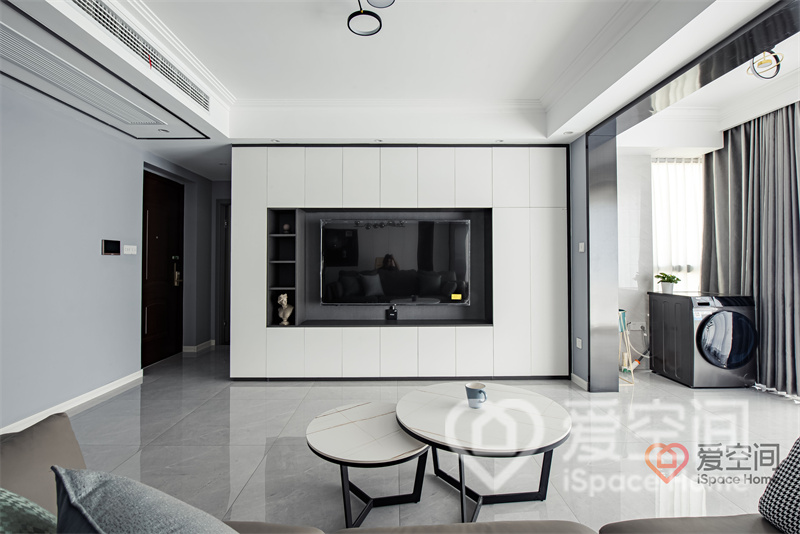 电视墙利用黑白搭配诉说都市美感，隐形柜门增加了客厅的储物空间，挂式电视打造出背景的视觉中心。