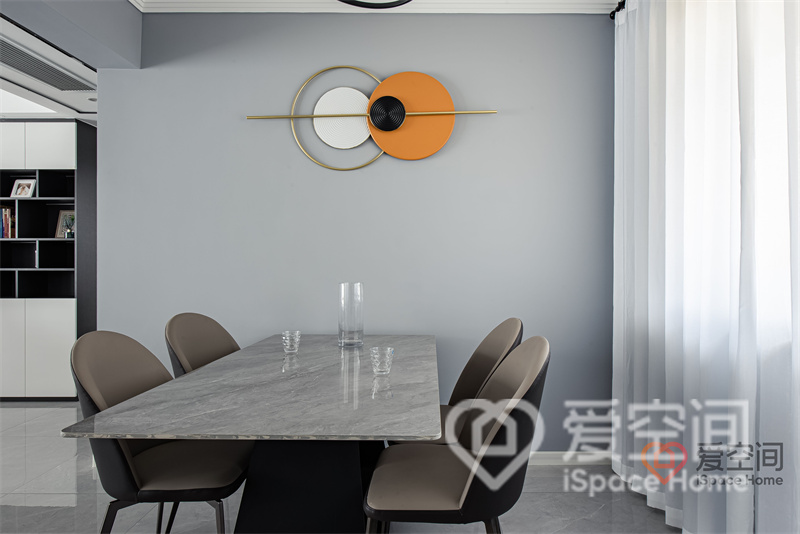 浅蓝色餐厅空间中，餐桌椅造型简单，格调雅致，配色含蓄内敛，橙色装饰元素带来活跃时尚的气息。