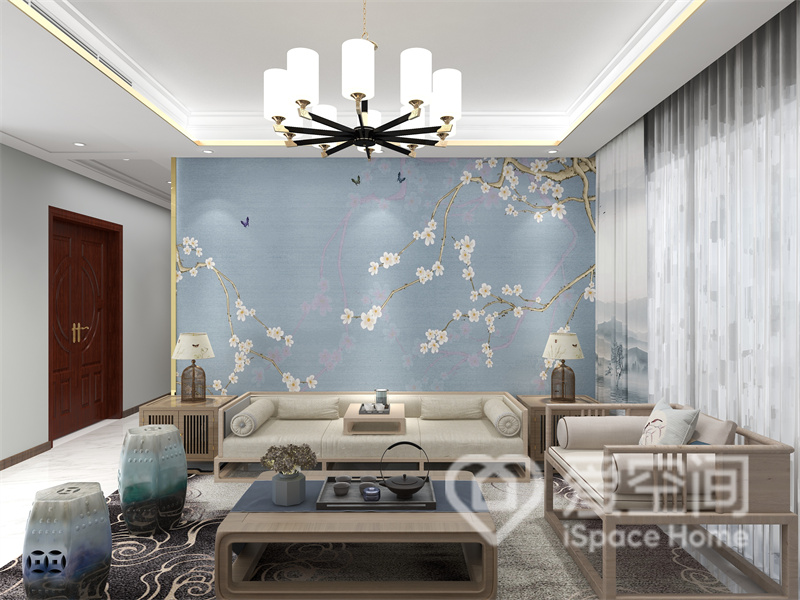 客厅以蓝色背景为底色，加以梅花点缀，塑造出宁静而雅致的中式氛围，米灰色沙发及原木家具带来温馨的禅意感。