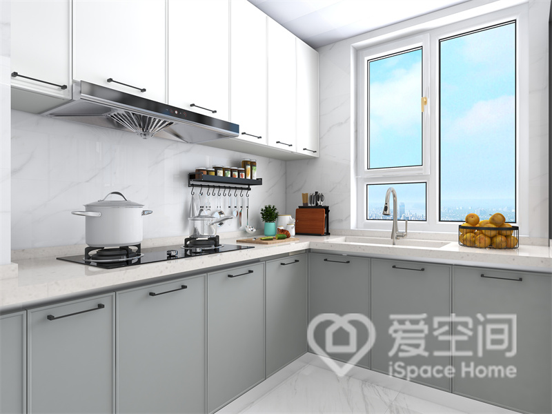 结合L型橱柜布局，空间显得大气而干净，白色吊柜与灰色地柜结合，让烹饪空间变得简单舒适了起来。